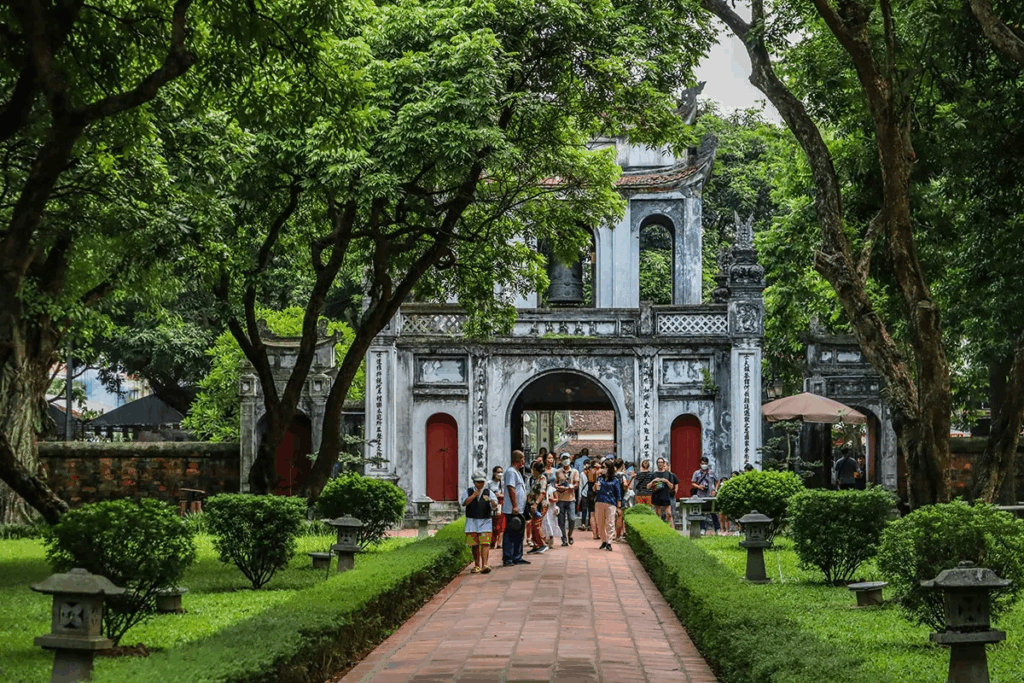 Shaded pathway through Temple of Literature with ancient trees and traditional architecture, a top cultural thing to do in Hanoi Vietnam