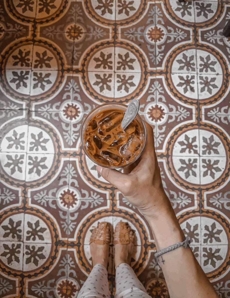 French colonial interior of Loading T Cafe featuring ornate tile floors and tall wooden shutters, among the best cafes in Hanoi for photography and egg coffee
