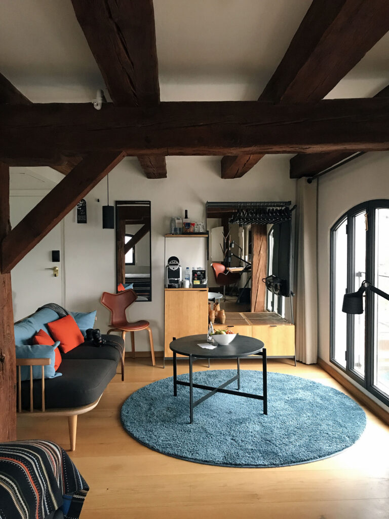 Stylish loft-style suite at 71 Nyhavn Hotel in Copenhagen featuring exposed wooden beams, Scandinavian furniture, soft natural light, and cozy modern Nordic design details. Nastasia Yakoub. All rights reserved. No reposts, reuse, or distribution without written permission.